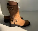 Brązowe zamszowe buty z klamrą i ozdobnym pierścieniem. Dowiedz się, jak dbać o zamszowe buty, by służyły latami.