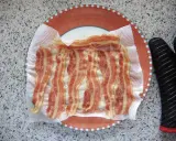 Fertig zubereitetes Bacon auf Küchenpapier auf einem Teller. Schnell und einfach in der Mikrowelle gemacht.