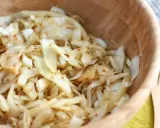 Salade de chou râpé assaisonnée de graines de sésame, servie dans un bol en bois.
