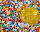 Złoty bitcoin wśród kolorowych kamyczków. Czy to symbol bogactwa, które James Howells stracił na zawsze?