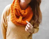 Persona con una bufanda naranja tejida, lista para el frío.