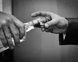 Dwie dłonie, jedna trzyma butelkę, druga odbiera klucz. To symbol tego, co powoduje alkohol: utratę kontroli i kluczy do własnego życia.