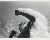 Underwater shot of a swimmer's arms and torso, creating a dramatic splash. The image captures the power and motion of a flip schulke.