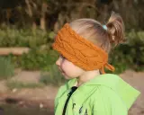 Niña con diadema de lana tejida, ideal para aprender como hacer diademas de lana para niñas.