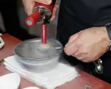 Chef usa sifón para crear texturas aireadas, ideal para recetas de espumas para sifón. Humo frío rodea el bol.