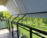Nowy markiza to świetny sposób, jak osłonić balkon w bloku przed słońcem. Drewniana podłoga i szklane balustrady dodają uroku.