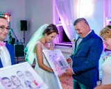 Para młoda z uśmiechem odbiera portrety. Elegancki ślub w stylu mafii, gdzie każdy detal jest dopracowany.