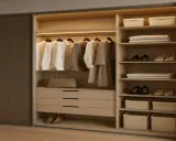 Armario empotrado moderno con ropa colgada, bolsos, zapatos y cestas organizadoras. Ideas para como hacer un armario empotrado funcional y elegante.