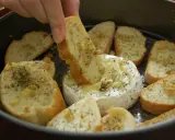 Ciepły, rozpływający się camembert z piekarnika, idealny do maczania w nim chrupiących grzanek z ziołami.