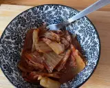 Miseczka z domowym kimchi, widelcem, na drewnianej desce.