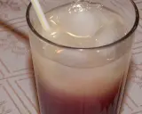 Szklanka z drinkiem z lodem i słomką, z widocznym podziałem na warstwy koloru.