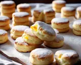 Délicieux biscuits cuillère saupoudrés de sucre glace, certains garnis d'une crème jaune. Parfait pour une recette facile et gourmande.