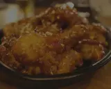 Délicieuse cuisse de poulet au four, nappée d'une sauce sucrée et parsemée de cacahuètes concassées. Un vrai régal !