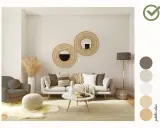 Soggiorno accogliente con divano, poltrona e pouf. Specchi rotondi in rattan e una palette colori neutri arredamento creano un'atmosfera rilassante.