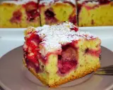 Wilgotne ciasto z mrożonymi truskawkami, posypane cukrem pudrem. Idealne na deser.