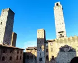 Wieże średniowiecznego miasta San Gimignano wznoszą się dumnie pod błękitnym niebem.
