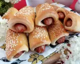 Złociste, pieczone mini hot dogi posypane sezamem, gotowe do podania. Idealne na przekąskę!
