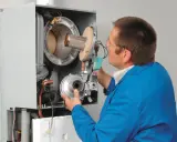 Serwisant sprawdza ciśnienie wody w kotle Viessmann Vitodens 050.