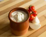Gęsty jogurt w glinianym naczyniu, pomidorki koktajlowe i cebula. Jak zmniejszyć ostrość potrawy? Dodaj jogurtu!