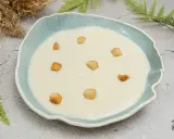 Crema de coliflor suave y cremosa, decorada con crujientes picatostes dorados en un cuenco azul.