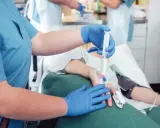 Pielęgniarka podaje lek pacjentowi przed kolonoskopią. Czy kolonoskopia boli? Znieczulenie minimalizuje dyskomfort.