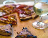 En saftig pizza med ett glas vitt vin till. Perfekt för en mysig kväll.