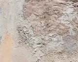 Texture d'un vieux mur dégradé, révélant des traces de salpêtre et des couches de peinture écaillée.