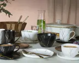 Elegancka zastawa stołowa z motywem złotych gałązek, idealna, by dowiedzieć się, jak podawać kawę gościom.