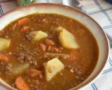 Un plato humeante de lentejas estofadas al estilo Arguiñano, con patatas y zanahorias, listo para disfrutar.
