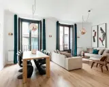 Amplio salón comedor rectangular de 25 metros con sofás, mesa de madera y sillas modernas.