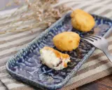 Deliciosa croqueta de jamón, cremosa por dentro y dorada por fuera, servida en un plato azul.