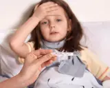 Chora dziewczynka z gorączką, której matka nie udziela informacji o dziecku. Termometr pokazuje podwyższoną temperaturę.