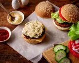 Pyszny burger z bogatym sosem do burgera, ketchupem i świeżymi dodatkami.