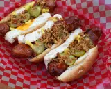 Heißer Hot Dog aus dem Airfryer, belegt mit Gurken, Zwiebeln und Senf. Perfekt für einen schnellen Snack!