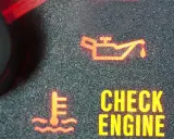 Czerwona kontrolka oleju świeci się na desce rozdzielczej, sygnalizując problem. Obok widoczny symbol termometru i napis "CHECK ENGINE".