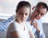 Mujer triste, hombre la señala. Una escena que evoca el trauma bonding español, donde el dolor crea un vínculo perverso.