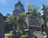Dziedziniec zamku w CS:GO, z kamienną rzeźbą rycerza i brukowaną ścieżką.