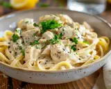 En krämig kyckling pasta med färsk persilja och svartpeppar i en skål.