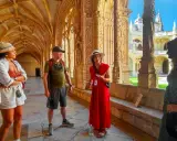 Besucher lauschen einer Führerin im Jeronimos Kloster. Die Architektur ist detailreich und beeindruckend.
