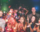 Gente celebrando con confeti y copas de champán. ¡Una fiesta perfecta para organizar despedida de soltero!