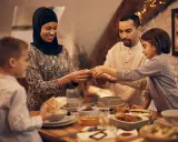 Familie feiert das Zuckerfest mit einem Festmahl. Sie teilen Brot und genießen das Beisammensein.