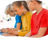 Trois enfants, dont mon fils, sont absorbés par leurs écrans.