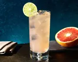 Erfrischender Greyhound Cocktail mit Eis, Limettenspalte und Grapefruit-Hälfte.