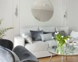 Jasny salon z sofą i fotelami. Białe ściany w salonie podkreślają nowoczesny charakter wnętrza.
