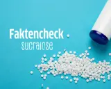 Faktencheck: Sucralose ungesund? Kleine weiße Tabletten und ein Spender auf blauem Hintergrund.