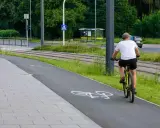 Mężczyzna na rowerze na ścieżce, obok torów tramwajowych. Uważaj, bo mandat za prowadzenie roweru pod wpływem alkoholu jest wysoki.
