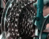 Zbliżenie na kasetę zębatek rowerowych i mocowanie przerzutki tylnej. Metalowe zębatki i łańcuch tworzą skomplikowany mechanizm.