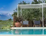 Piscina con vista sulle montagne innevate, ideale per una vacanza in Abruzzo montagna. Relax sotto il pergolato tra ulivi secolari.