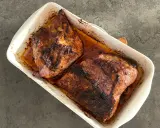 Två saftiga bitar av grillad pluma ligger i en vit ugnsform, redo att serveras.