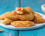 Sofficini fatti in casa dorati e croccanti, ripieni di pomodoro e formaggio filante, pronti per essere gustati.